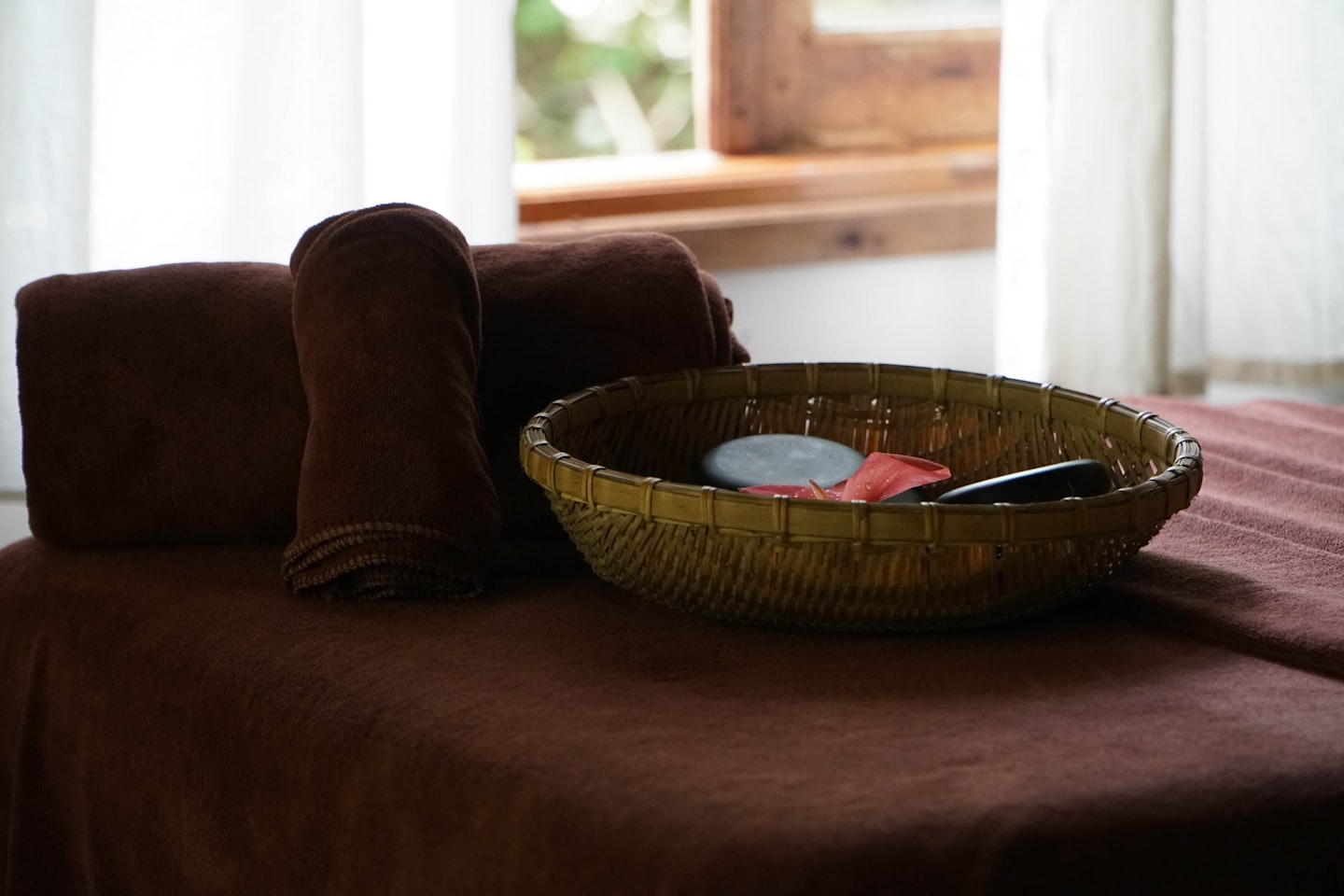 Massage bed with towels and hot stones in a spa.