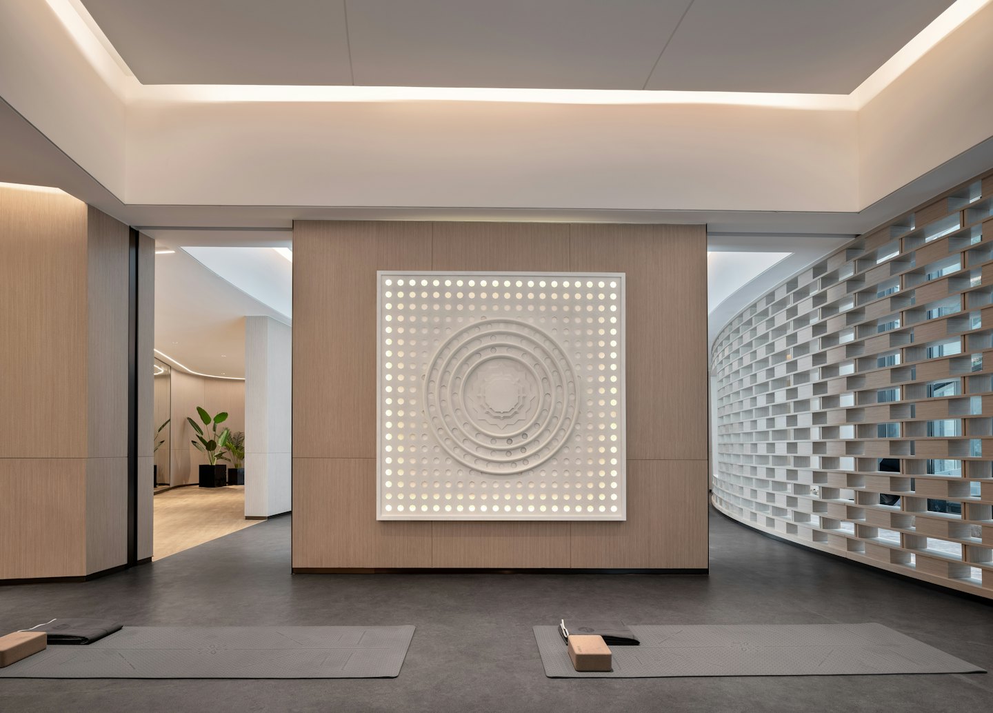 Two grey yoga mats placed in a modern wellness studio.
